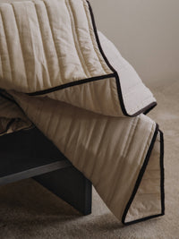 Detail of the quilting and dark chocolate piping on the ferm LIVING Vari bedspread