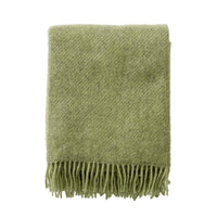 Klippan Gotland brushed wool throw in pear green, folded on a white background