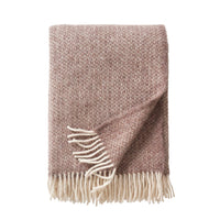 Klippan Lima alpaca and lambswool throw in sand, folded with white fringe on a white background