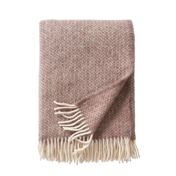 Klippan Lima alpaca and lambswool throw in sand, folded with white fringe on a white background