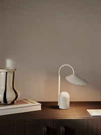 ferm LIVING Arum portable lamp styled outdoors on a terrace table