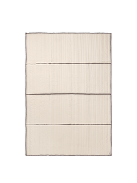 ferm LIVING Vari quilted bedspread in natural with dark chocolate piping, folded on a neutral background