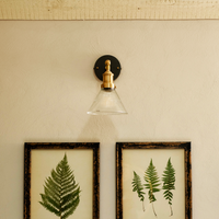Brooklyn glass funnel brass wall light fitted in a barn bedroom