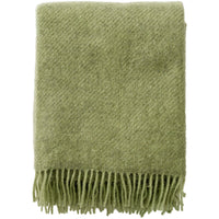 Folded Klippan Gotland throw in pear showing the brushed twill weave and fringe