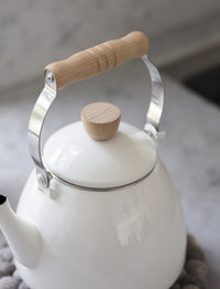 White enamel stove kettle with handle raised