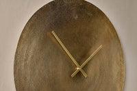 Angled close-up of the Okota clock's hammered brass surface