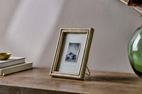 Pambani frame styled with books and a green glass vase