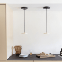 Pearl white Asteria Micro pendant lit above a dining table