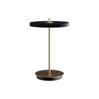 UMAGE Asteria Move portable lamp in black with brass stem on white background