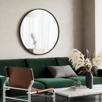 Umbra Hub black wall mirror hanging above a console table in a modern hallway