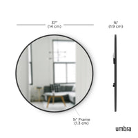 Umbra Hub black round mirror in a bedroom setting