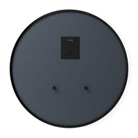 Umbra Hub round mirror styled on a wall beside natural-toned furniture