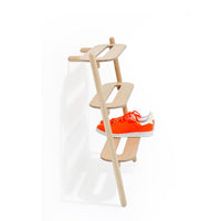 Wireworks Heel Bar shoe rack in solid oak leaning against a hallway wall