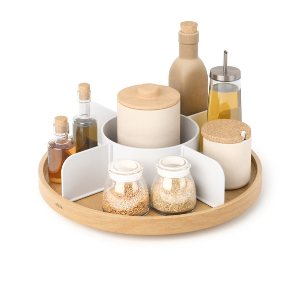 Umbra Bellwood lazy susan in natural wood and white filled with oils, jars and spice bottles