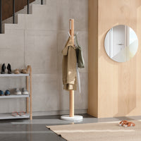Close view of the Umbra Flapper coat rack's white flip-down hooks on the natural rubberwood pole